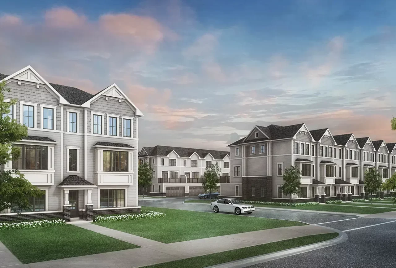 Modern townhouses with car, green lawn, and sky.